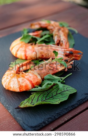 Grilled shrimps on slate plate, outdoor shot