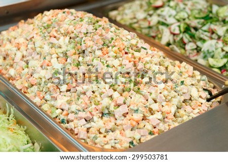 Russian salad in gastronomical containers in shop or restaurant