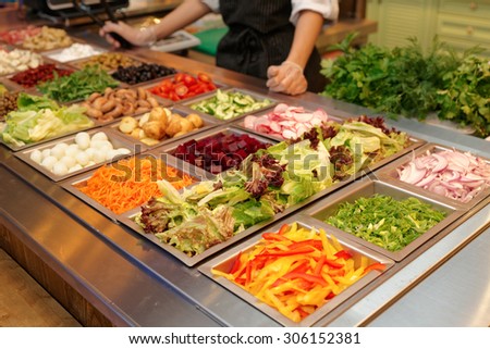 Salad bar with various fresh vegetables and other foods