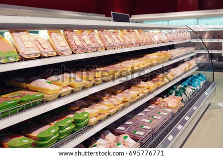 Fresh chicken meat on supermarket shelf, all logos removed, toned image