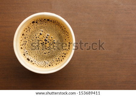 Top View Of A Paper Cup Of Black Coffee On Wooden Table