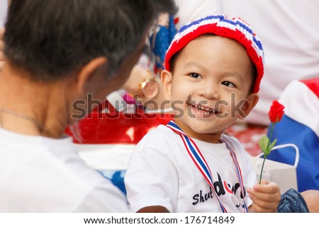 BANGKOK, THAILAND:FEB 14, 2014 : Unidentified boy smile and holding the rose in Anti-government protest at Chit Lom Road area on February 14, 2014 in Bangkok, Thailand