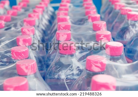 Pink screw cap of  water bottles in plastic wrap