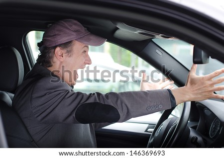 Angry upset man yelling and screaming while driving his car
