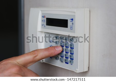Finger setting security alarm, pressing keys on keypad