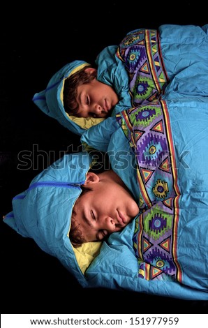 Two young boys sleep in sleeping bags
