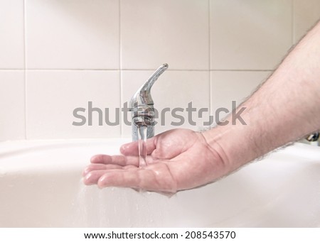 Hand under water flow in the sink