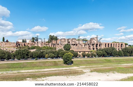 ROME - AUGUST 26: The Palatine hill facing the Circus Maximus under a blue sky. Some tourists rest under the shadow of the trees on Via dei Cerchi on August 26, 2014 in Rome.