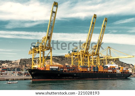 BARCELONA, SPAIN - JANUARY 29: Cargo unloads its containers on the deck of Barcelona commercial harbor on January 29, 2014