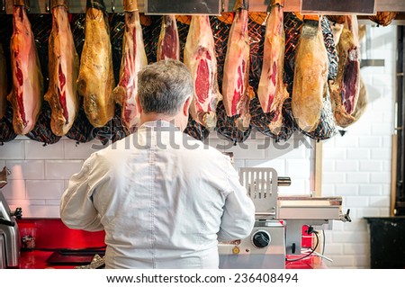 MADRID - NOVEMBER 22: Pork seller prepares some hams (Jamon) for the market day at the historic Market of San Miguel on November 22, 2014