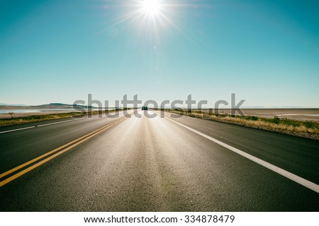 Freeway / road in the desert - at the horizon a car speeds up