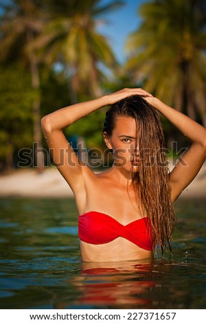 Beautiful asian girl in a sea in red bikini