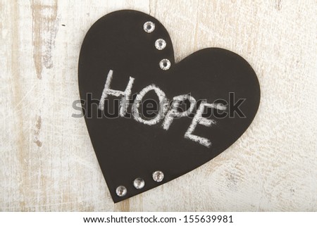 Heart shaped chalk boards with words of inspiration on it on wood background