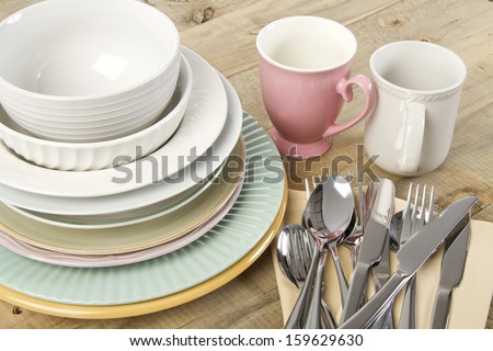 Cutlery, crockery and mugs ready to be set for a meal