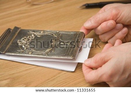 drawing a paper from silver notebook cover for writing a note