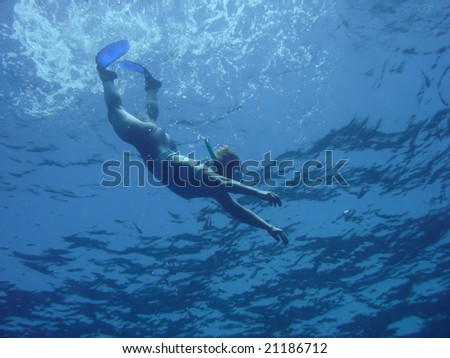 woman snorkels in deep blue sea