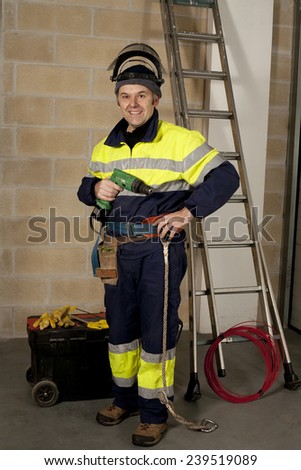Electrician dressed in work clothes and drill