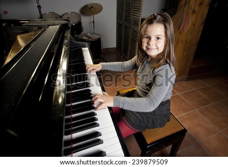 Eight year old girl is happy playing the piano