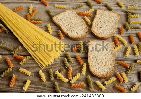 Toasts integrals, spaghetti and pasta spirals on rustic background