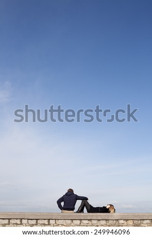 Young couple watching the horizon with blue sky