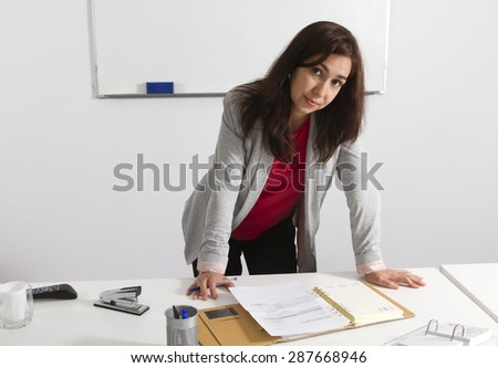 Middle aged businesswoman checking her agenda in the office