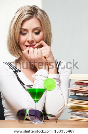 Woman sits at her desk and compares work and leisure opportunities.