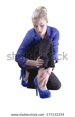 A young woman hold her leg in pain after falling over on her high heels./High heels pain/High heels fall.