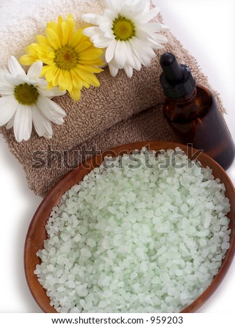 Spa towels, flowers, bath salts in a wooden bowl and essential oil.