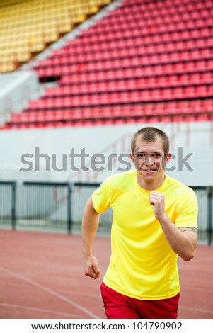 young  athlete is at the start of the treadmill at the stadium