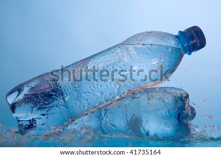 Water in bottle with drops on a surface