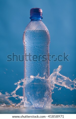Water in bottle with drops on a surface