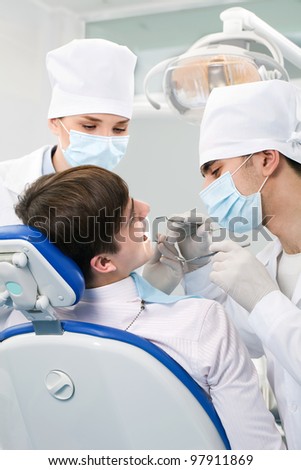 patient dental office two doctors with the tools in the hands of
