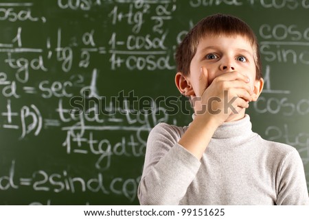 student against a blackboard with a raised hand
