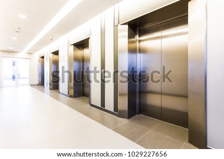 Modern steel elevator cabins in a business lobby or Hotel, Store, interior, office,perspective wide angle. Three elevators in hotel lobby.