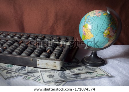 Still life globe with abacus and money.