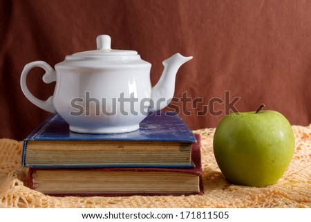 Still life book with apple and tea kit