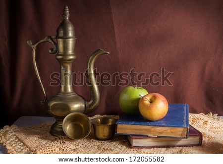 Still life book with apples and tea kit .