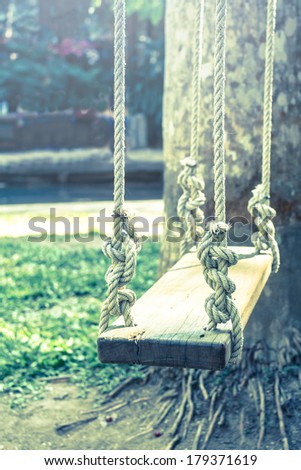 Wooden swing in garden,vintage light style.