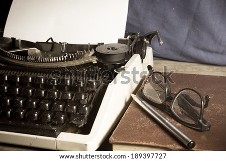Typewriter with antique book and eyeglasses,vintage color.