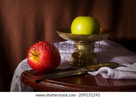 Still life red and green apples with metal dish and knife.