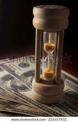 Hourglass with money,time and business concept.