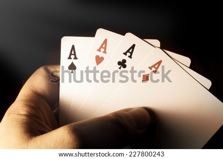 Four Aces cards in hand for play gamble,vintage filtered.