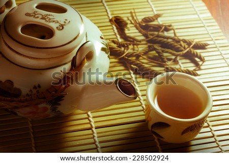 Tea set with leaves on bamboo mat,sepia color filtered.