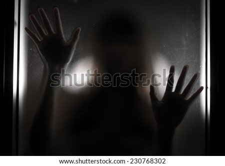 Woman shadow behind translucent mirror.