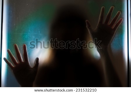 Woman shadow behind translucent mirror.