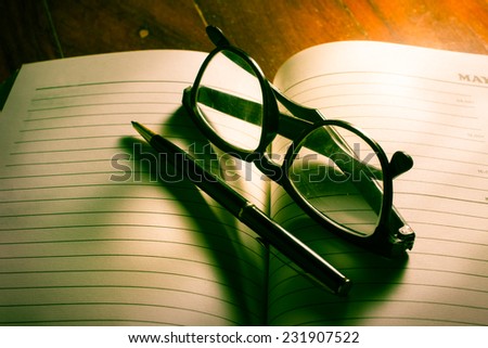 Eyeglasses and pen on plan book.
