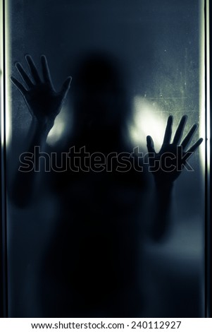 Woman shadow behind translucent mirror,blue tone color filtered.