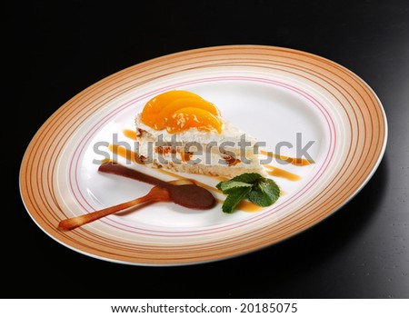 Dessert cake with mango slice on black background