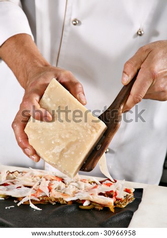 Chief grate cheese on professional kitchen detail