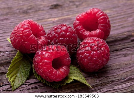 Raspberry fruit closeup on old wood background